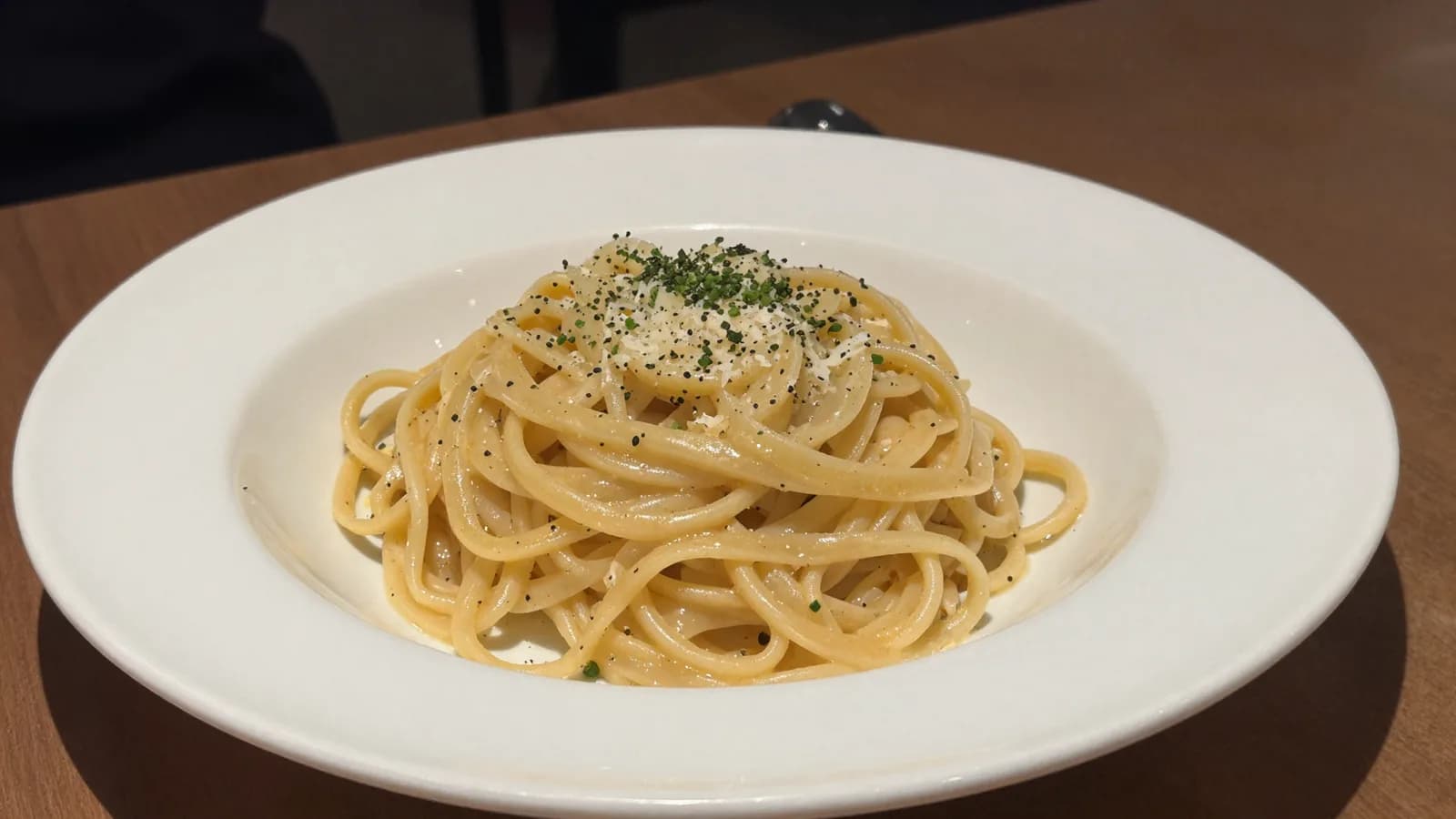 Phone snapshot of a plated Cacio e Pepe on a restaurant table